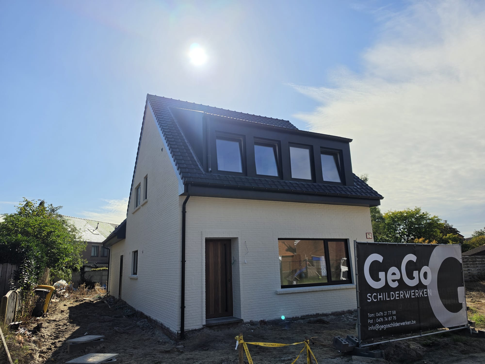 Wit geschilderde woning met de werfbanner van GeGo Schilderwerken