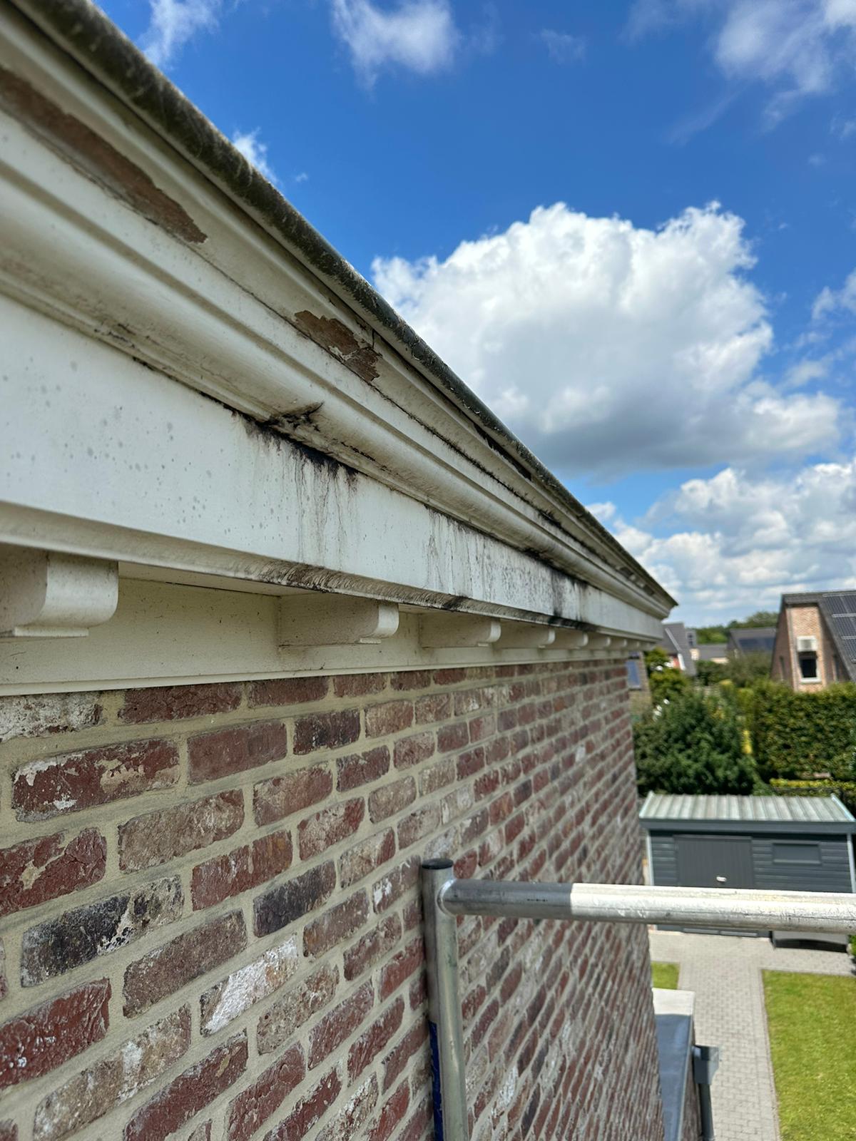 Voor: houten kroonlijst met afbladderende verf en vuilstrepen